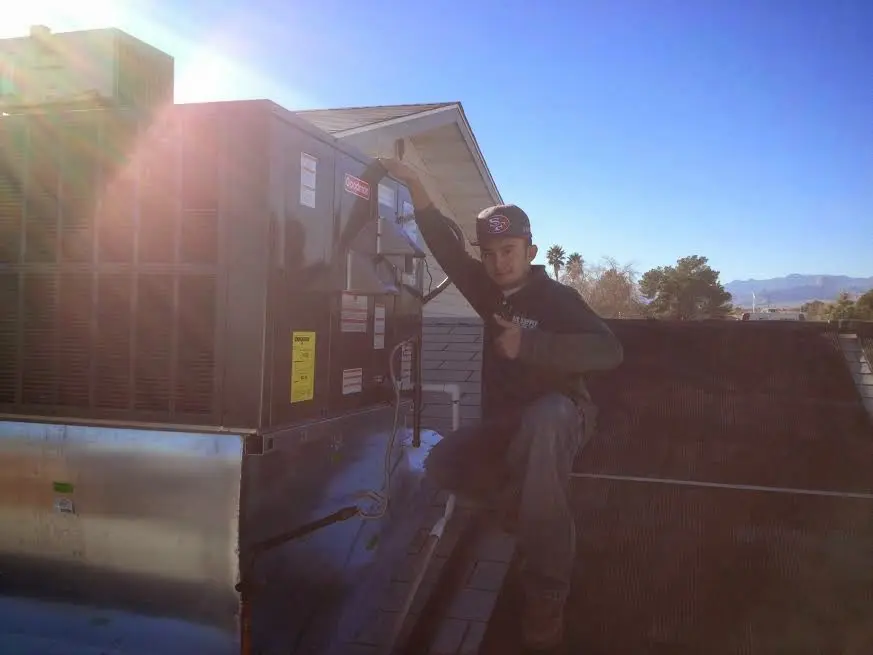 HVAC technician performing Air Duct Cleaning on a rooftop unit in Fredonia